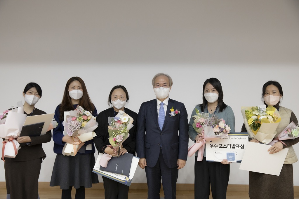 NIH 컨퍼런스에서 꽃과 상금을 들고 있는 6명의 사람들을 찍은 사진